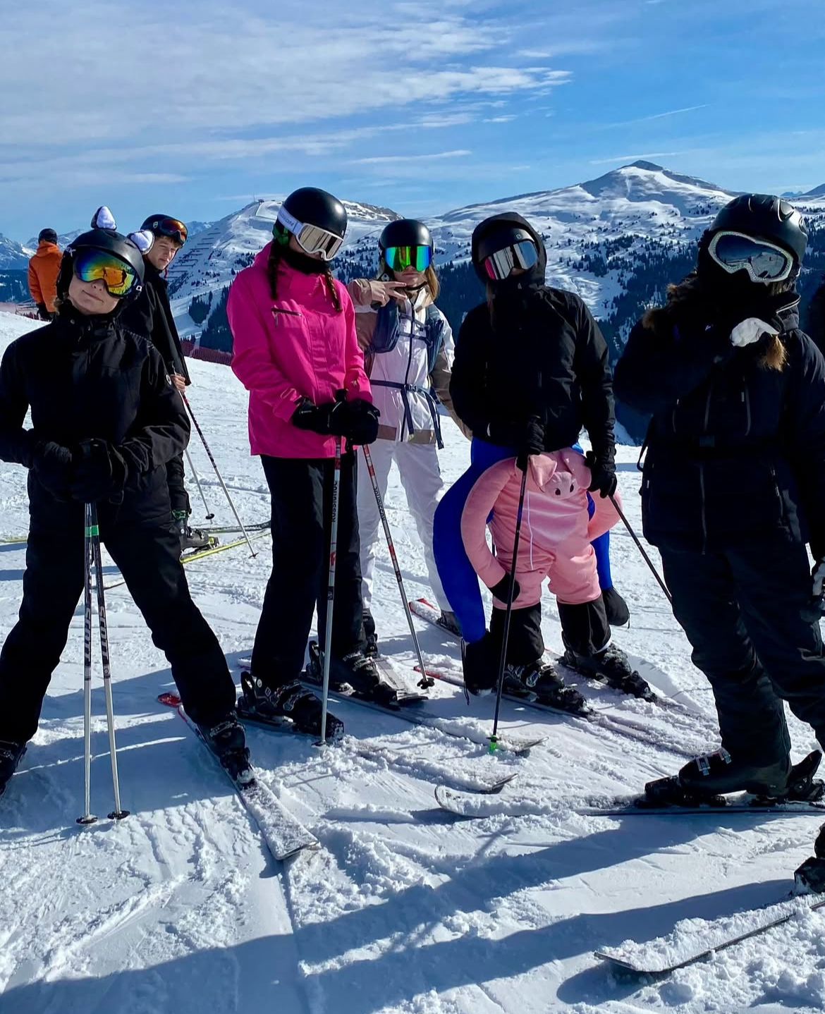 Teenagere står på ski på bjerg