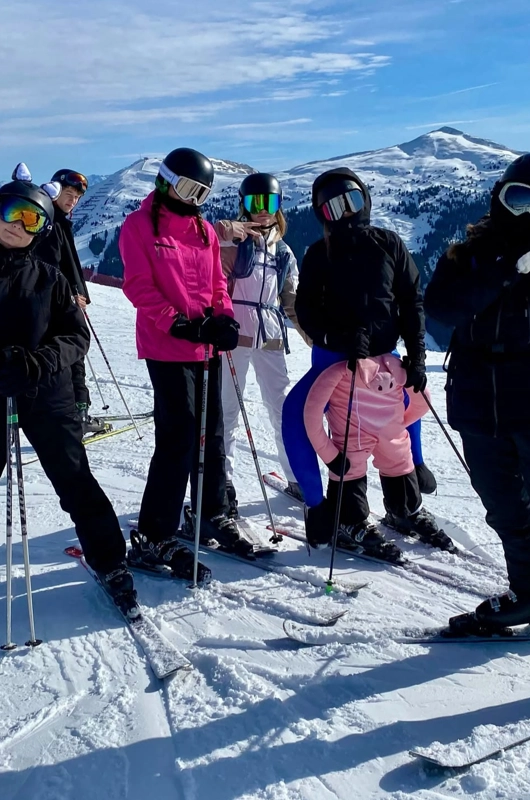 Teenagere står på ski på bjerg